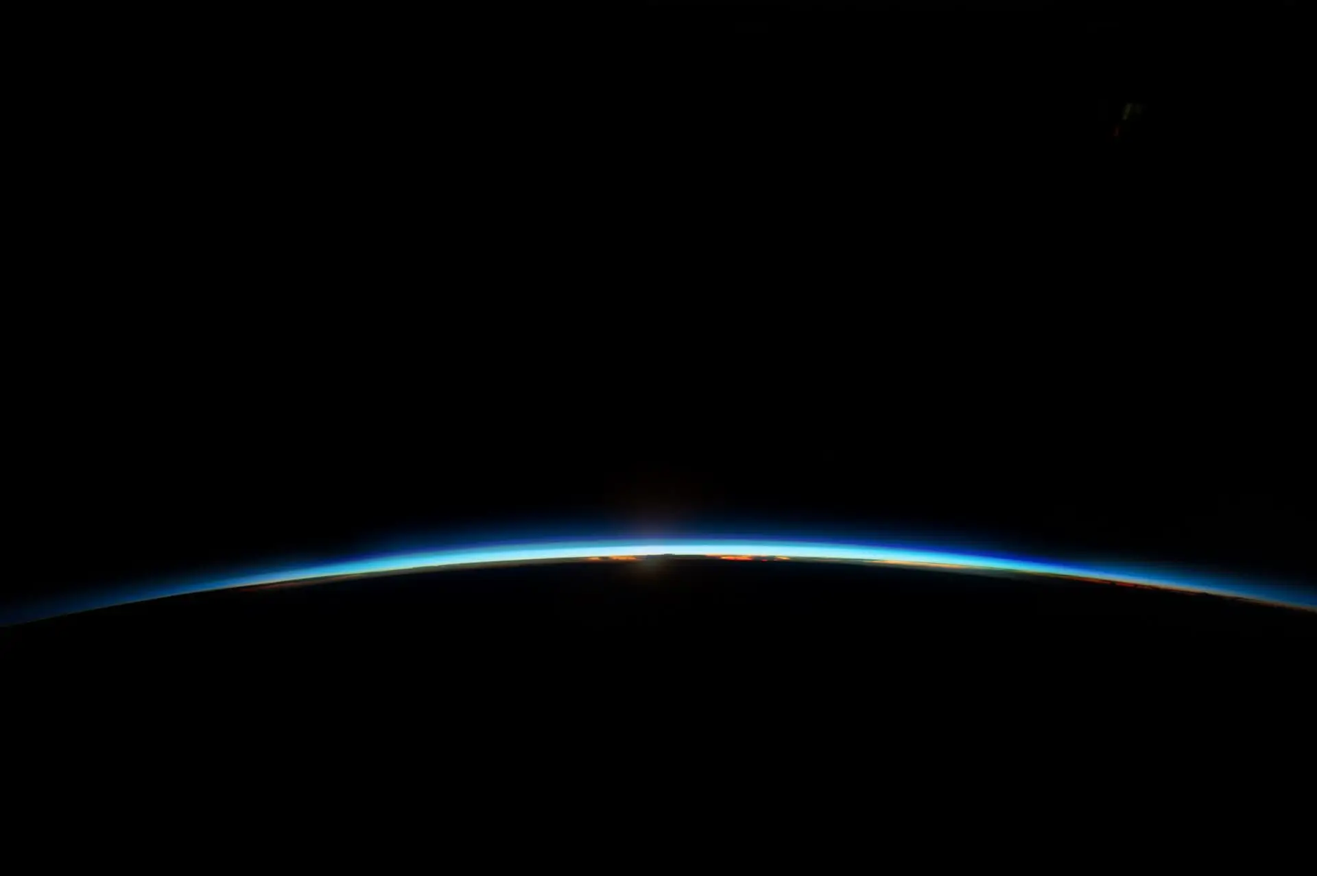 View of Earth’s horizon from space with a dark sky background, symbolizing a global perspective and innovation.